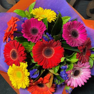 Gerbera bouquet from above, purple paper and orange wrapping on the outsides